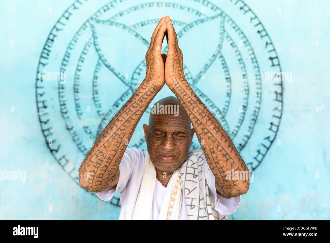 Mitglied der Ramnani Samaj Schule betet mit dem hinduistischen Gott namens Lord Rama, tätowiert über seinen ganzen Körper, was seinen Glauben widerspiegelt, Shivrinarayan, Indien Stockfoto