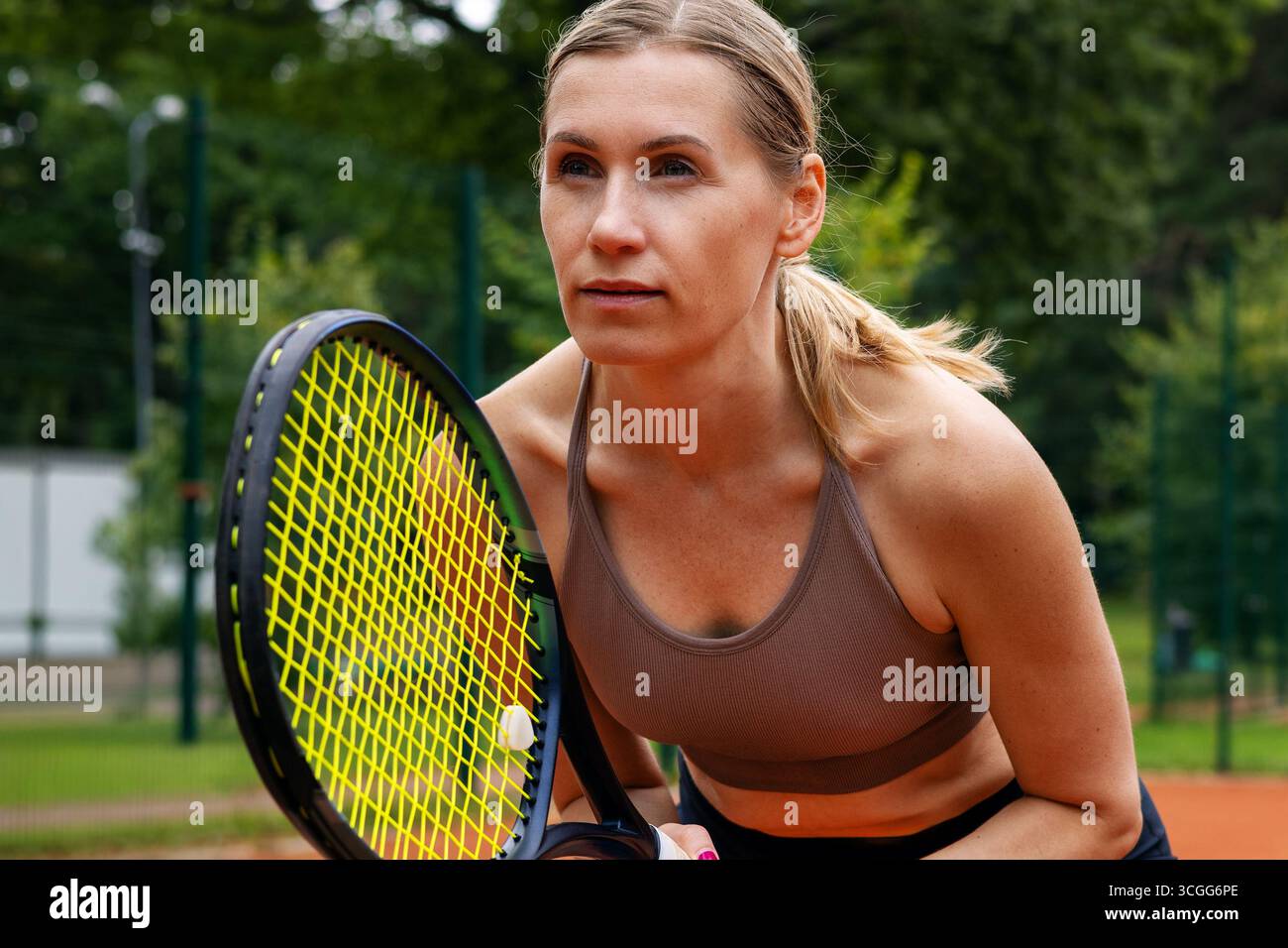 Konzentrierte Tennisspielerin auf dem Platz im Freien, bereit für das Spiel Stockfoto