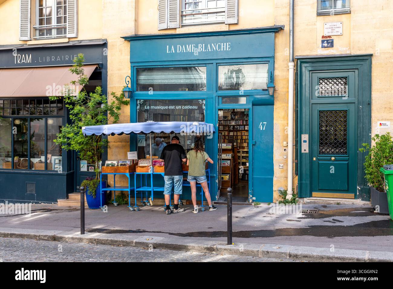 Paris, Frankreich, 08.25.2025. Leute, die sich alte Schallplatten ansehen, vor einem Musikladen im 5. Arrondissement von Paris Stockfoto