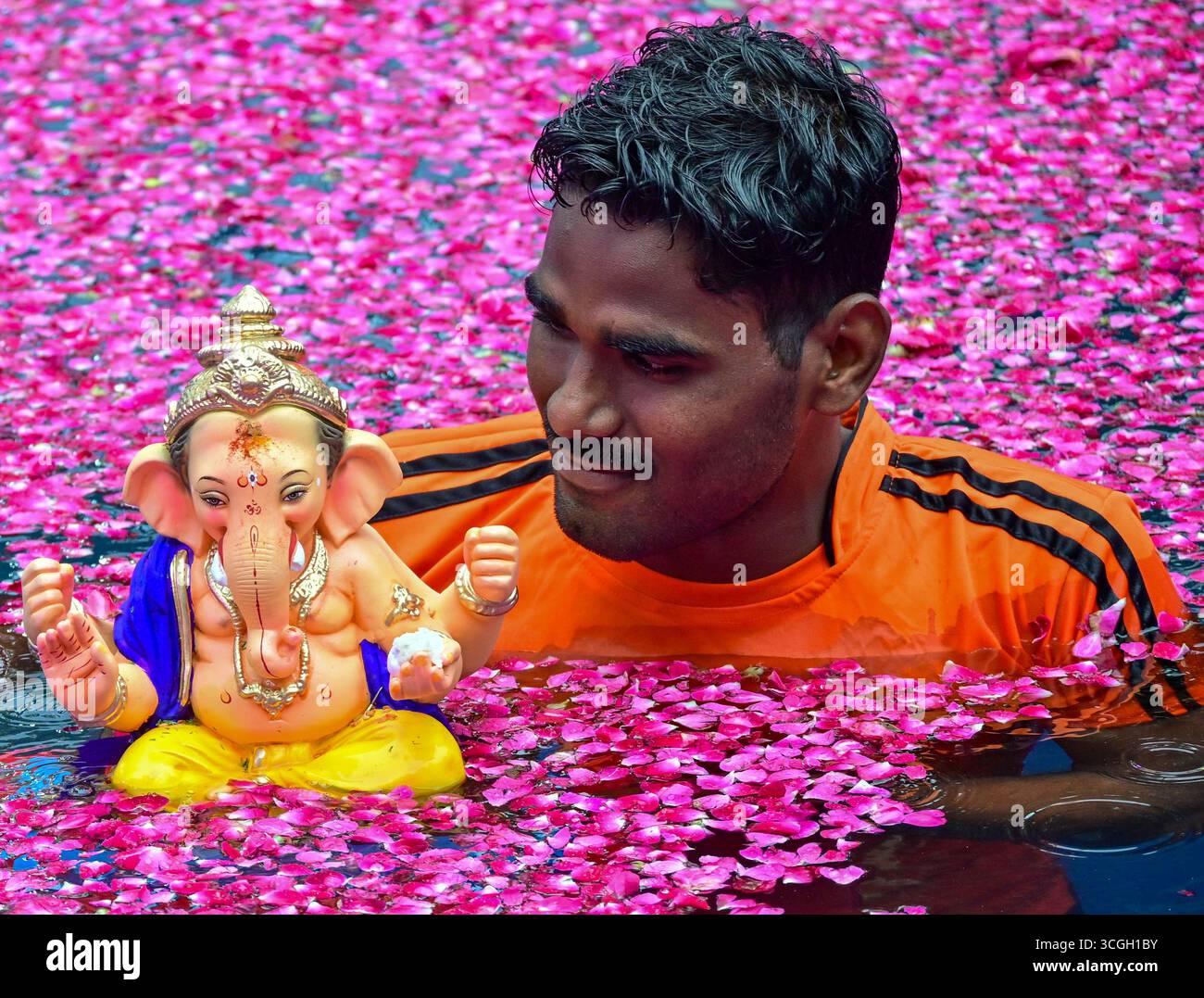 Ein Freiwilliger trägt ein Idol der hinduistischen Gottheit Ganesha, um während des Ganesh Chaturthi Festivals in Mumbai in künstliche Teiche einzutauchen. Stockfoto