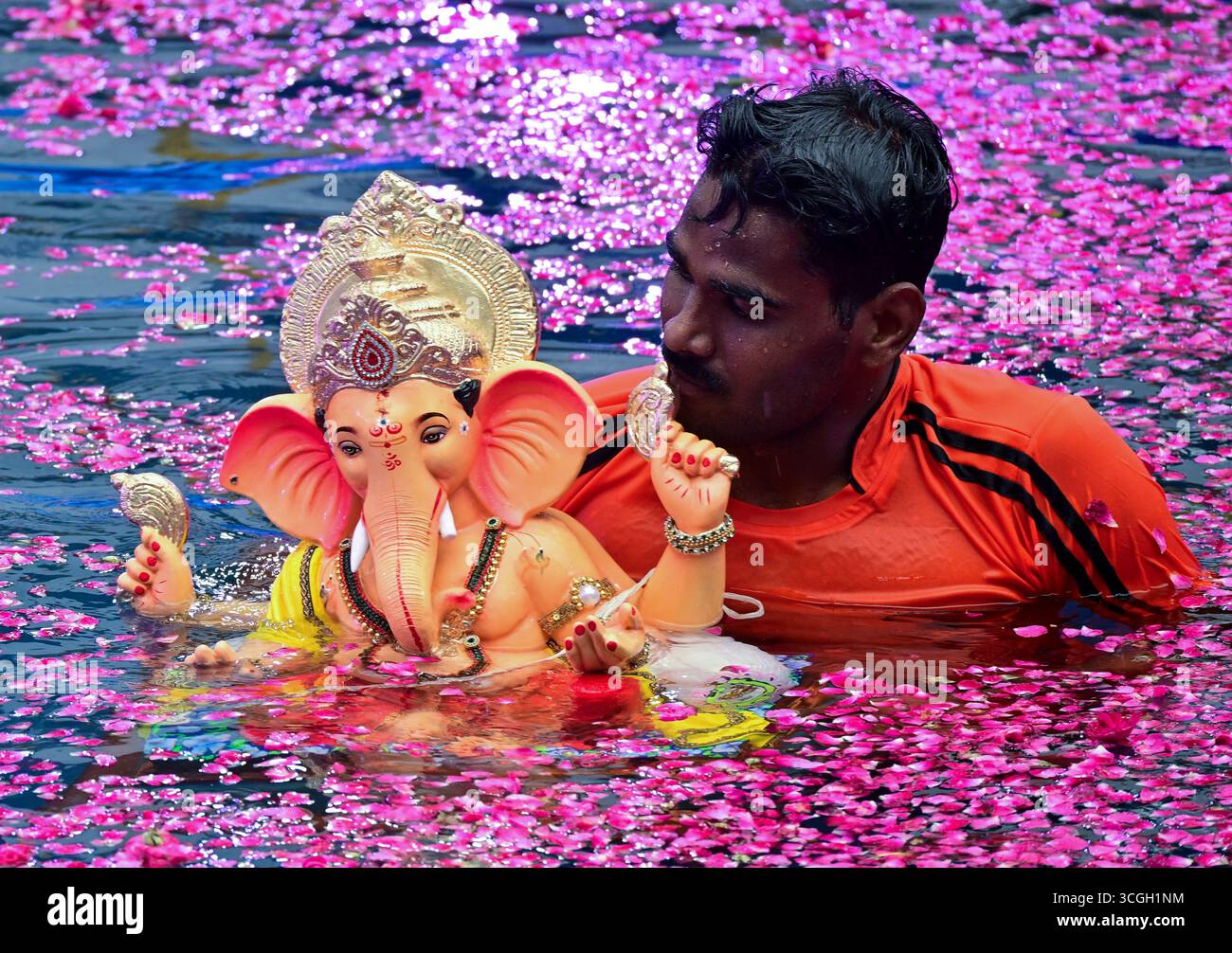 Ein Freiwilliger trägt ein Idol der hinduistischen Gottheit Ganesha, um während des Ganesh Chaturthi Festivals in Mumbai in künstliche Teiche einzutauchen. Stockfoto