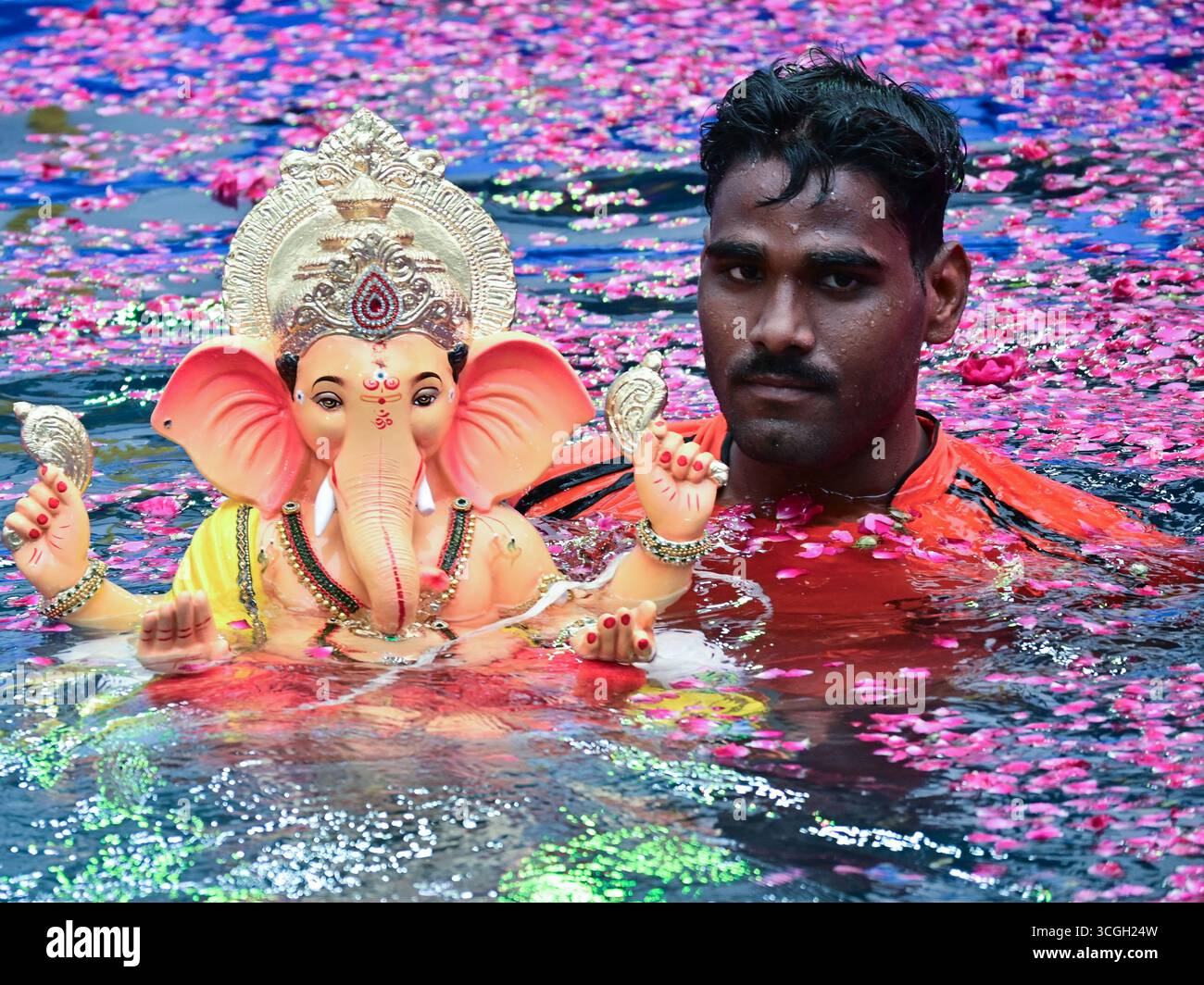 Ein Freiwilliger trägt ein Idol der hinduistischen Gottheit Ganesha, um während des Ganesh Chaturthi Festivals in Mumbai in künstliche Teiche einzutauchen. Stockfoto
