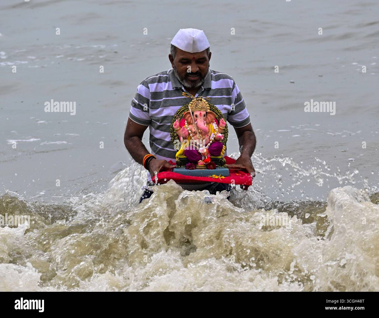 Ein Anhänger trägt ein Idol der hinduistischen Gottheit Ganesha, um während des Ganesh Chaturthi Festivals in Indien Mumbai.in in das Arabische Meer einzutauchen. Stockfoto