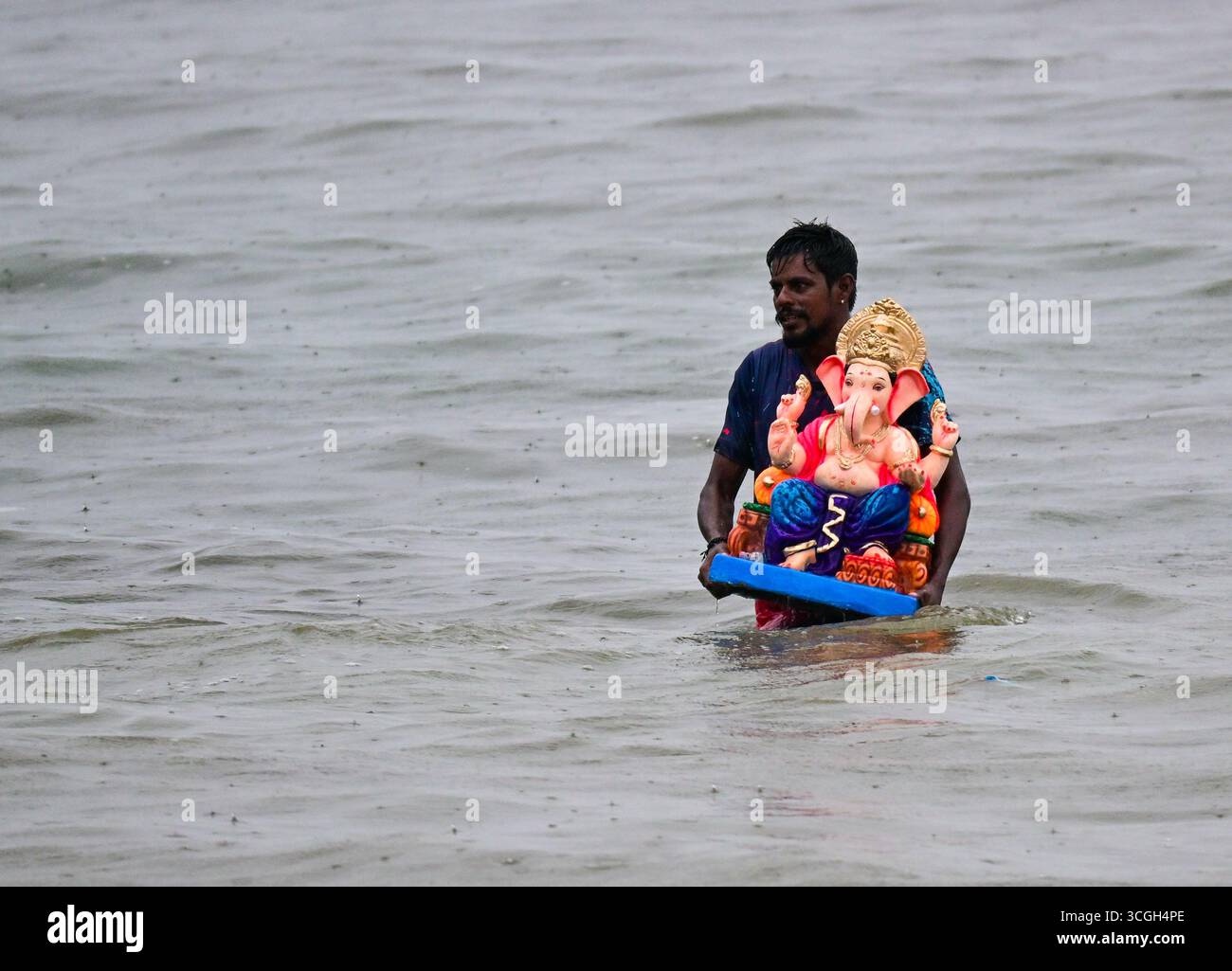 Ein Anhänger trägt ein Idol der hinduistischen Gottheit Ganesha, um während des Ganesh Chaturthi Festivals in Indien Mumbai.in in das Arabische Meer einzutauchen. Stockfoto