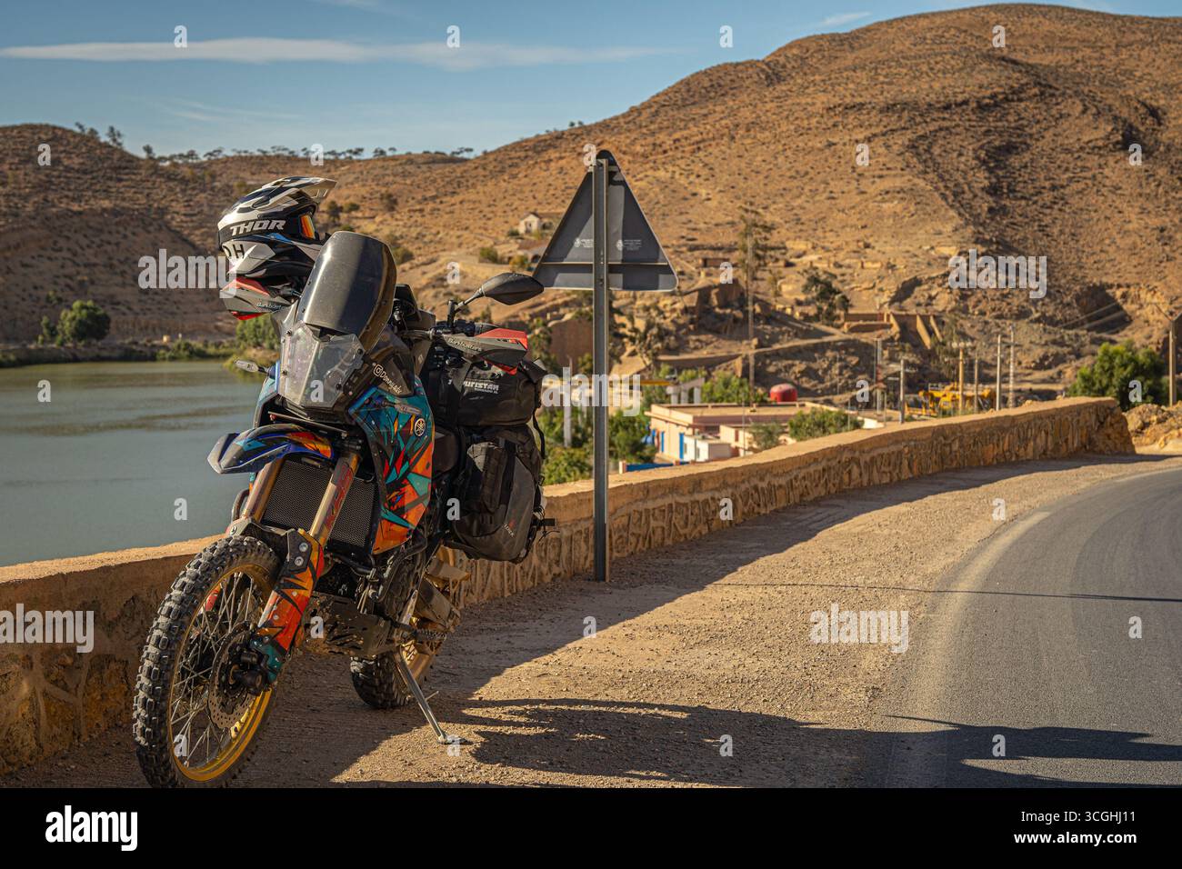 Yamaha Tenere 700 Abenteuer-Motorrad auf marokkanischer Bergstraße in der Nähe von Dorf und Fluss, perfekte Kulisse für Touren und Reisen im Gelände Stockfoto