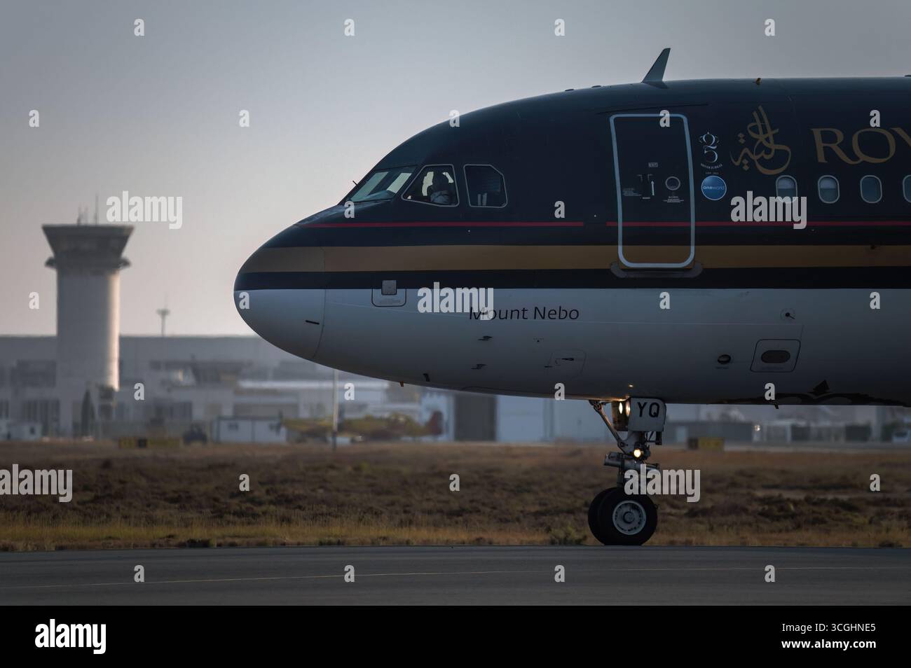Larnaca, Zypern - 29. Juni 2024: Royal Jordanian Airbus A320 auf der Landebahn des Larnaca International Airport, Zypern, mit Kontrollturm im Hintergrund Stockfoto