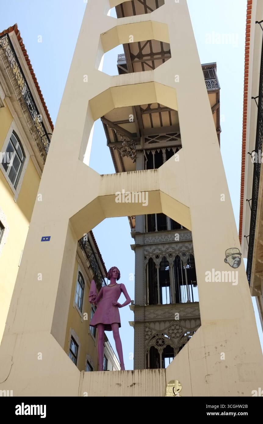 Straße (Rua) Santa Justa, mit Blick auf pinkfarbene Satue/Skulptur und Santa Justa Liftstruktur und traditionelle Gebäude (Aufzug von Raoul de Mesnier) Stockfoto