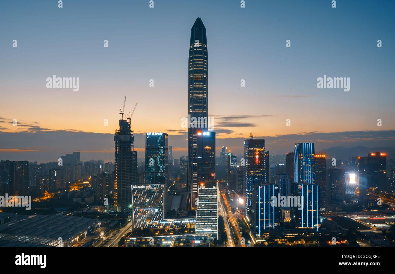 Die hohen Türme von Shenzhen, China, leuchten während der Dämmerung mit den Lichtern der Stadt. Stockfoto