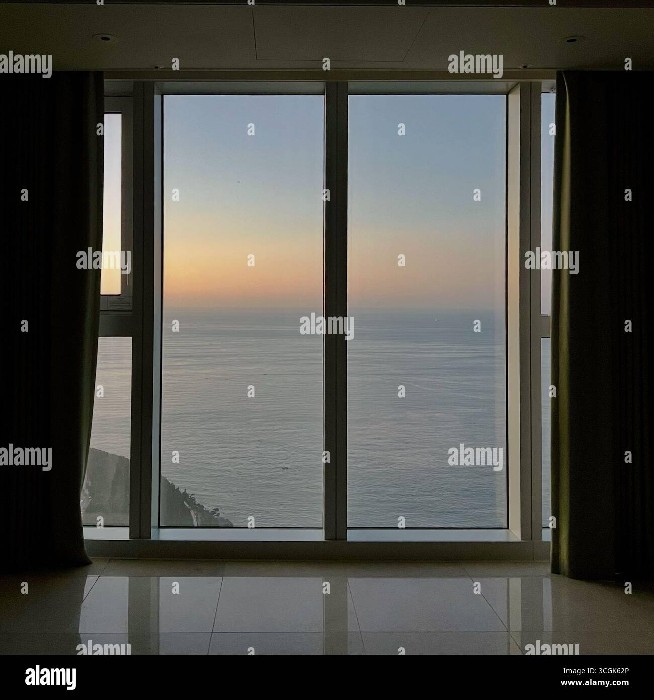 Blick auf den Sonnenaufgang am frühen Morgen vom Hochhaus in Haeundae, Busan, Südkorea, mit weichem Licht und bewölktem Himmel. - Smartphone-aufgenommenes Stockfoto