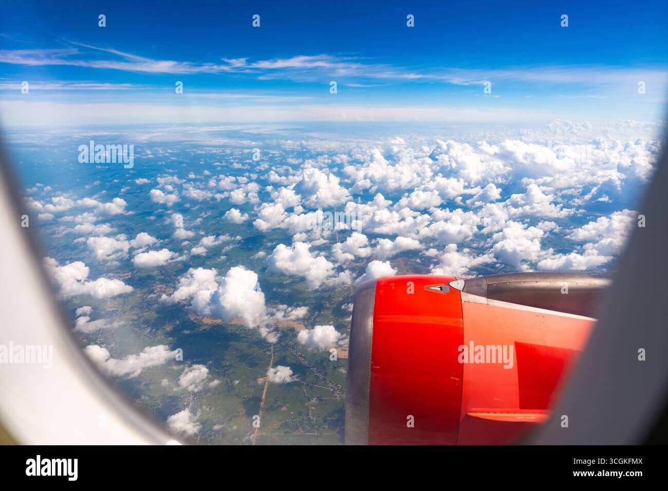Blick aus dem Flugzeugfenster mit Flugzeugmotor, blauem Himmel und weißen Wolken. Die Luftperspektive symbolisiert Reisen, Urlaub, Freiheit und Abenteuer Stockfoto Blick aus dem Flugzeugfenster mit Flugzeugmotor, blauem Himmel und weißen Wolken. Die Luftperspektive symbolisiert Reisen, Urlaub, Freiheit und Abenteuer Stockfoto