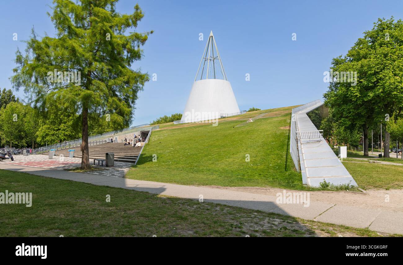 Das markante Design der TU Delft Bibliothek mit ihrem grasbedeckten Dach und einer markanten Kegelstruktur vor einem hellblauen Himmel auf einer sonnigen da Stockfoto