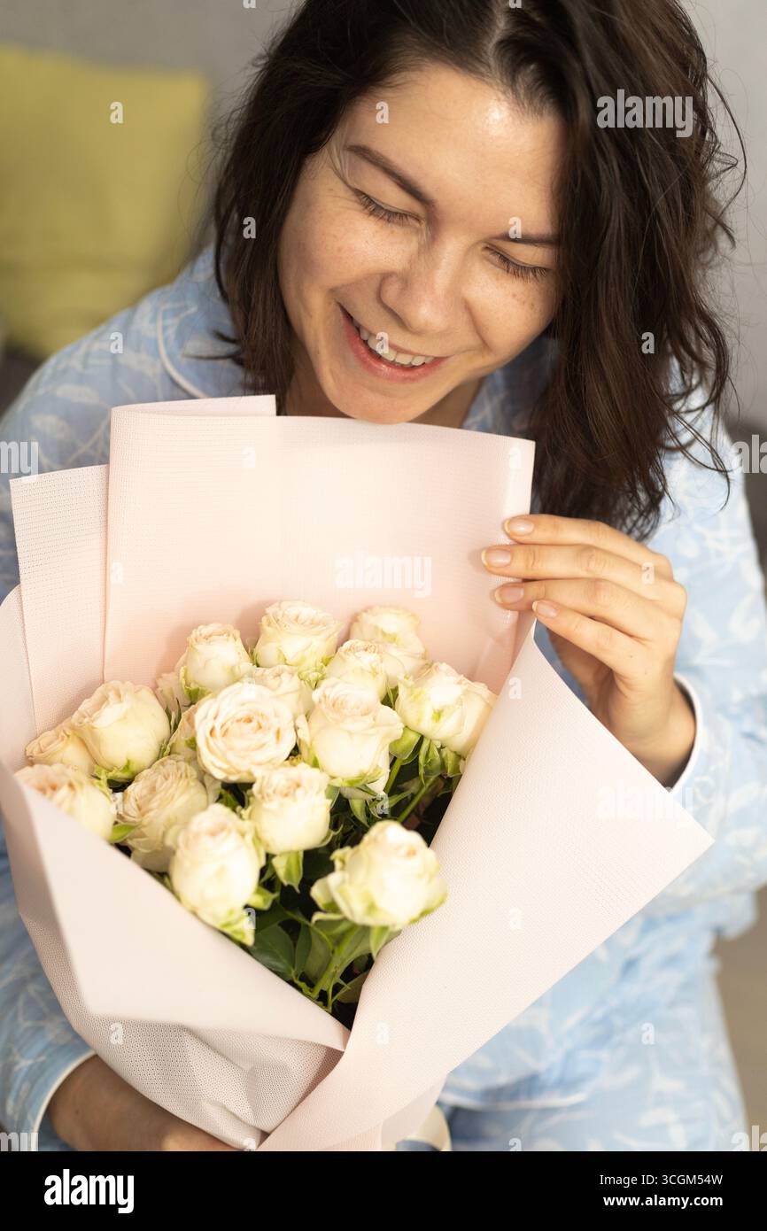 Eine junge Dame mit Rosen, die warm lächeln Stockfoto