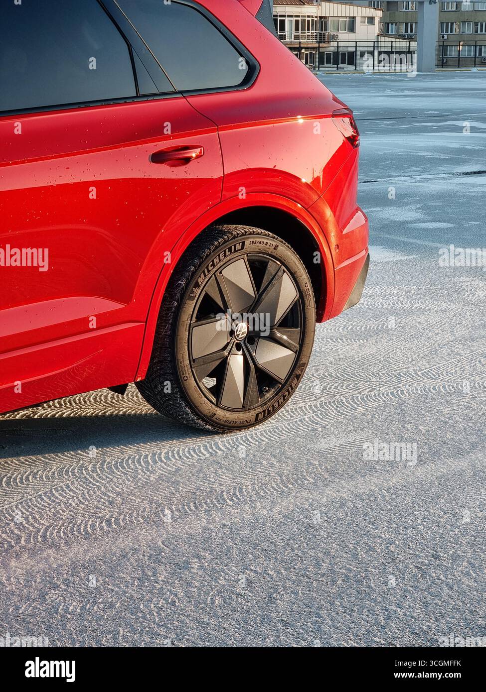 Hinterrad und Teil des roten Autos auf Schnee. Der Volkswagen Touareg mit Michelin Winterreifen ist bereit für schneebedeckten Wetter. Stockfoto