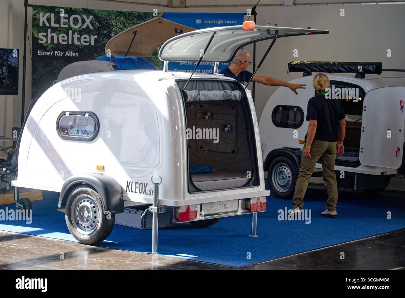 Düsseldorf, Deutschland. August 2025. Besucher des „Caravan Salon – Fachmesse für Caravaning, Camping und Outdoor-Tourismus“ sehen den Campinganhänger Shelter von Kleox. Bis Zum 7 . Im September werden mehr als 810 Aussteller in 15 Messehallen und auf dem Freigelände die Produkte und Dienstleistungen der Branche präsentieren. Quelle: Henning Kaiser/dpa/Alamy Live News Stockfoto