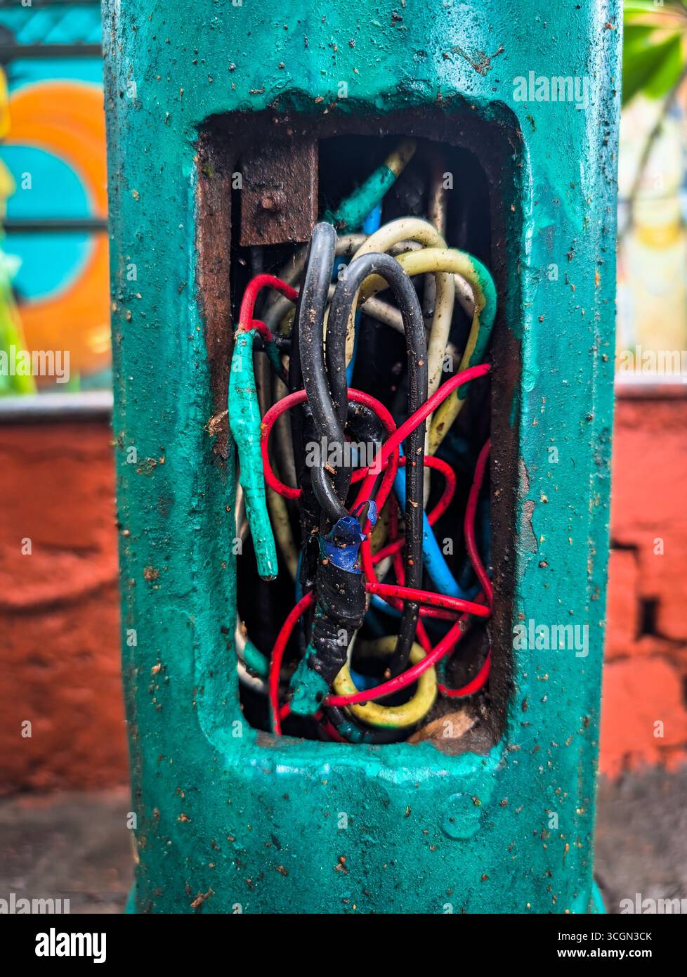 Freiliegende elektrische Kabel in einem grünen Metallmast. Stockfoto