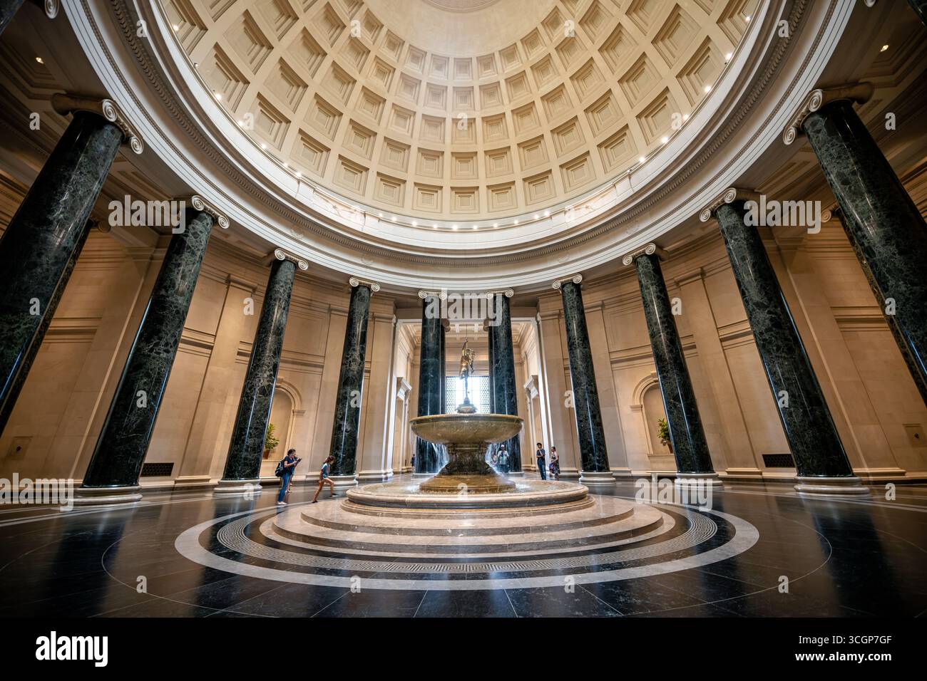 National Gallery of Art West Building Main Rotunda Bronze Mercury Fountain Washington DC // WASHINGTON DC – die Main Rotunda des West Building der National Gallery of Art ist mit einem großen Brunnen ausgestattet, auf dem eine Bronzekonstruktion der Mercury-Skulptur von Reinhold Begas aus dem Jahr 1878 steht. Dieses große neoklassizistische Interieur ist durch seine vom Pantheon inspirierte Kassettenkuppel und die massiven antiken Marmorsäulen des Verde mit ionischen Kapitellen gekennzeichnet. Das vom Architekten John Russell Pope entworfene West Building wurde 1941 eröffnet und beherbergt europäische und amerikanische Kunst vom Mittelalter bis zum frühen 20. Jahrhundert. Der National Galler Stockfoto