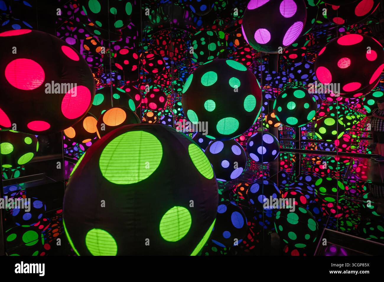 Yayoi Kusama Infinity Mirrored Room Polka Dot Hirshhorn Museum Washington DC // WASHINGTON DC - Yayoi Kusamas Infinity Mirrored Room Polka Dot ist eine immersive Kunstinstallation im Hirshhorn Museum and Sculpture Garden. Dieses lebendige Kunstwerk des gefeierten japanischen Künstlers zeigt beleuchtete, bunte Kugeln mit Polka-Punktmuster, die sich in einer spiegelnden Umgebung spiegeln. Die Reflexionen erzeugen eine Illusion von unendlichem Raum, charakteristisch für Kusamas gefeierte „Infinity Mirrored Room“-Serie. Das Hirshhorn Museum, Teil der Smithsonian Institution, ist ein bekanntes Museum für moderne und zeitgenössische Kunst Stockfoto