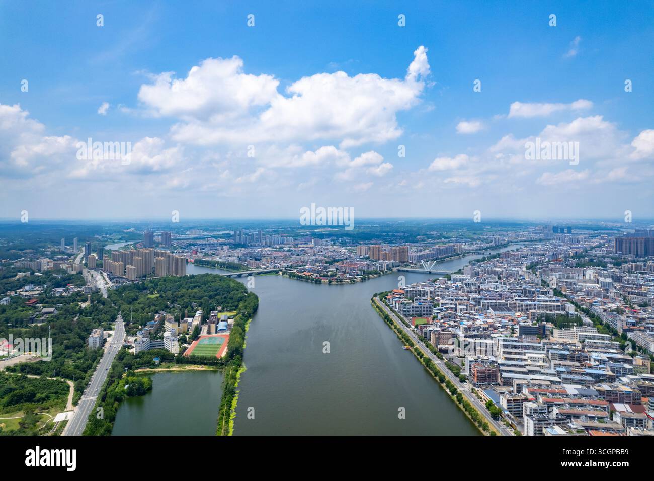 Das Luftpanorama zeigt eine geschäftige Stadt mit einem Fluss, der durch urbane Architektur und Grünflächen in Suizhou, Hubei, China fließt. Stockfoto