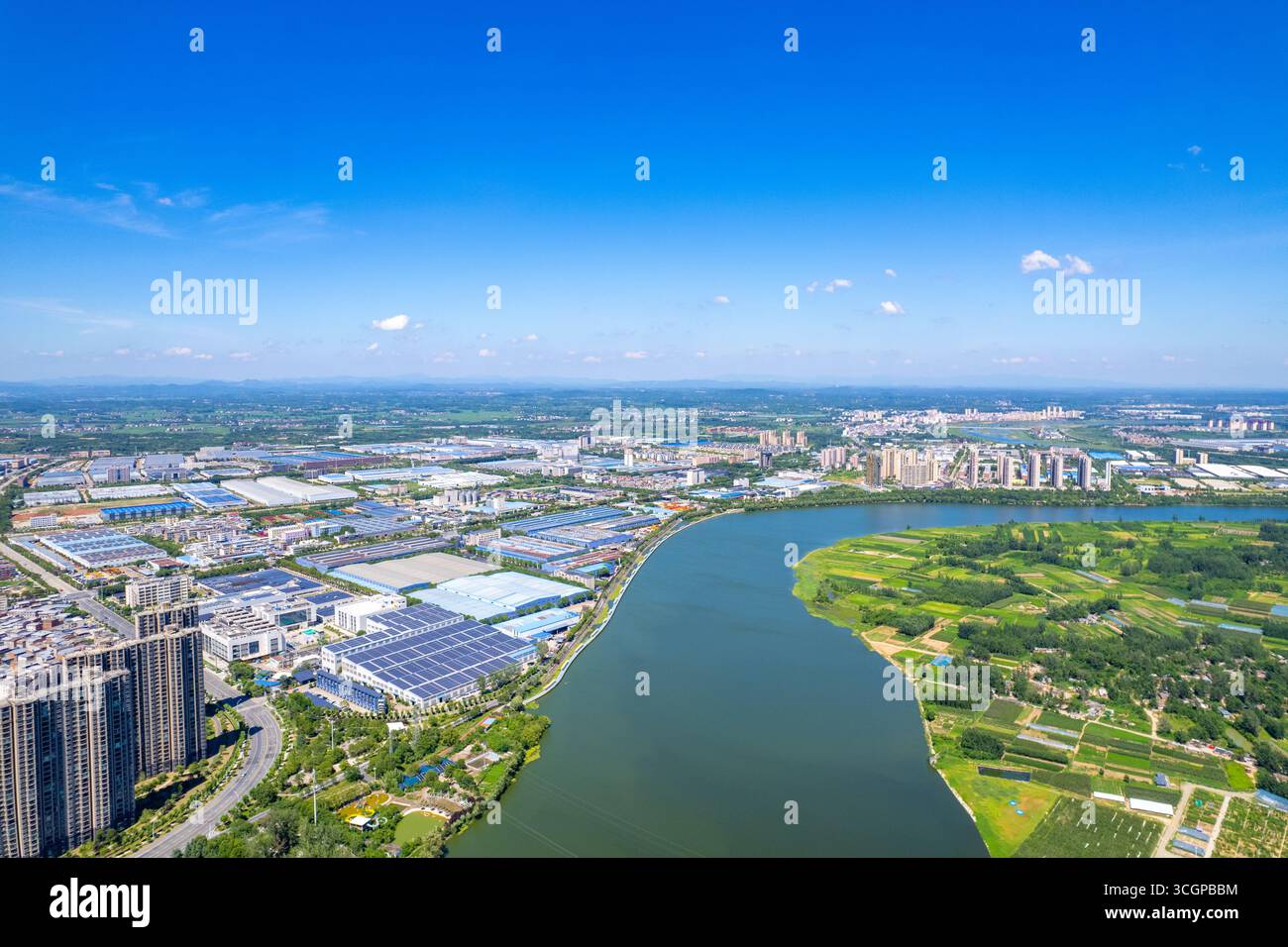 Eine Luftperspektive zeigt die sich entwickelnde Landschaft von Suizhou, Hubei, China, mit einem Fluss, der durch städtische Entwicklungen und natürliche Umgebungen fließt. Stockfoto