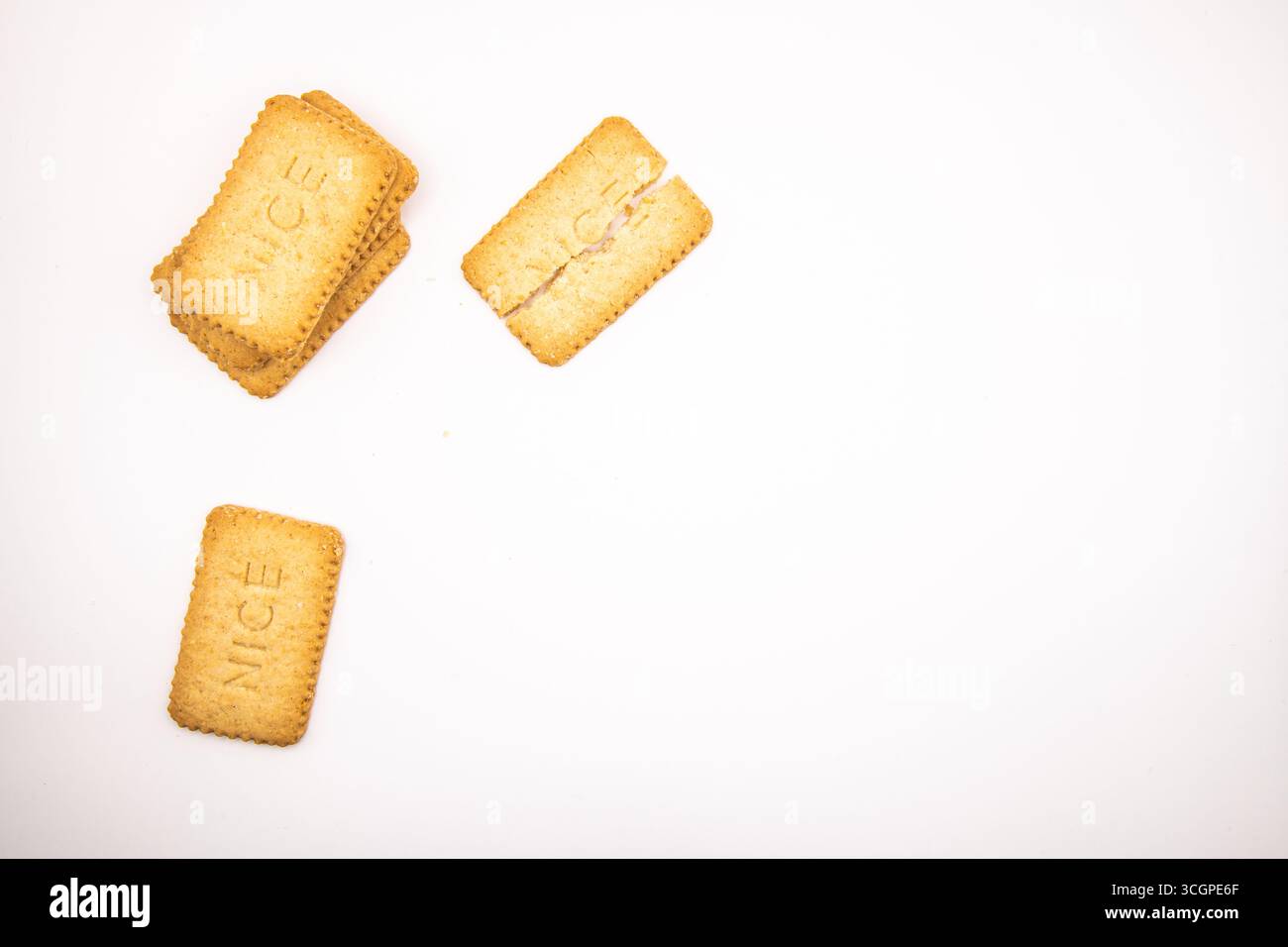 Auswahl an goldenen Nizza-Keksen auf einem sauberen weißen Hintergrund, ideal für Speisen, Snacks, Desserts, süße Leckereien, und Backkonzepte. Stockfoto