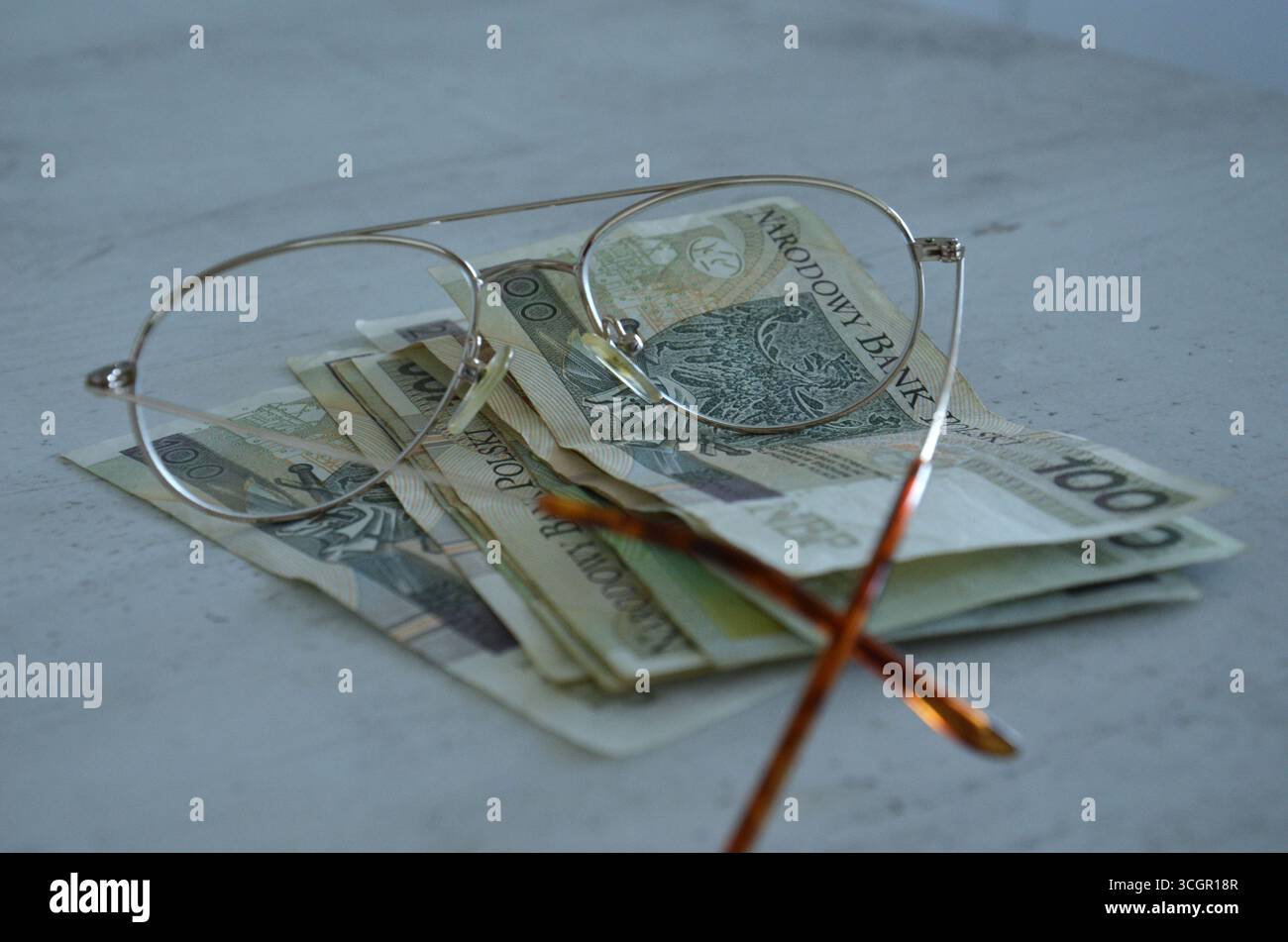Geld auf dem Tisch mit Gläsern – Finanz- und Investitionskonzept Stockfoto