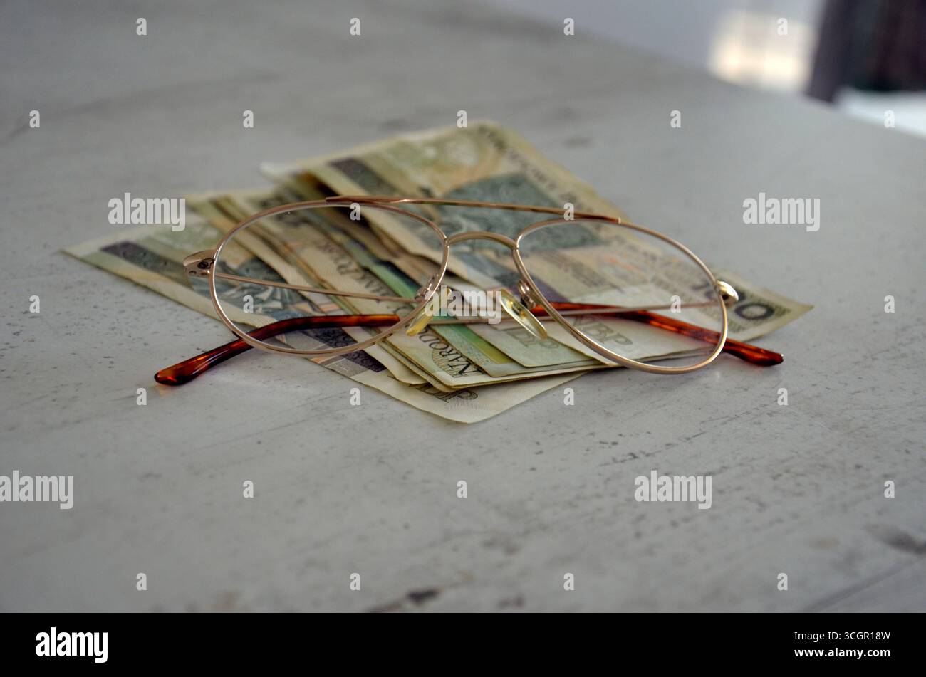 Geld auf dem Tisch mit Gläsern – Finanz- und Investitionskonzept Stockfoto