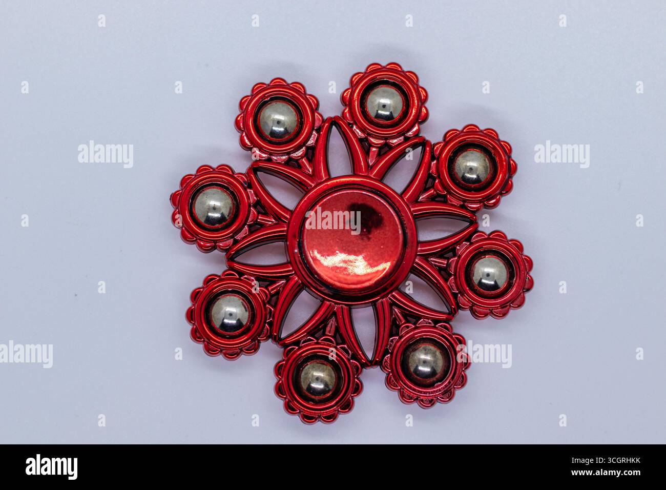 Zahnradkreisel in glänzend roter Form für die Entlastung auf einer Ebenen Oberfläche Stockfoto