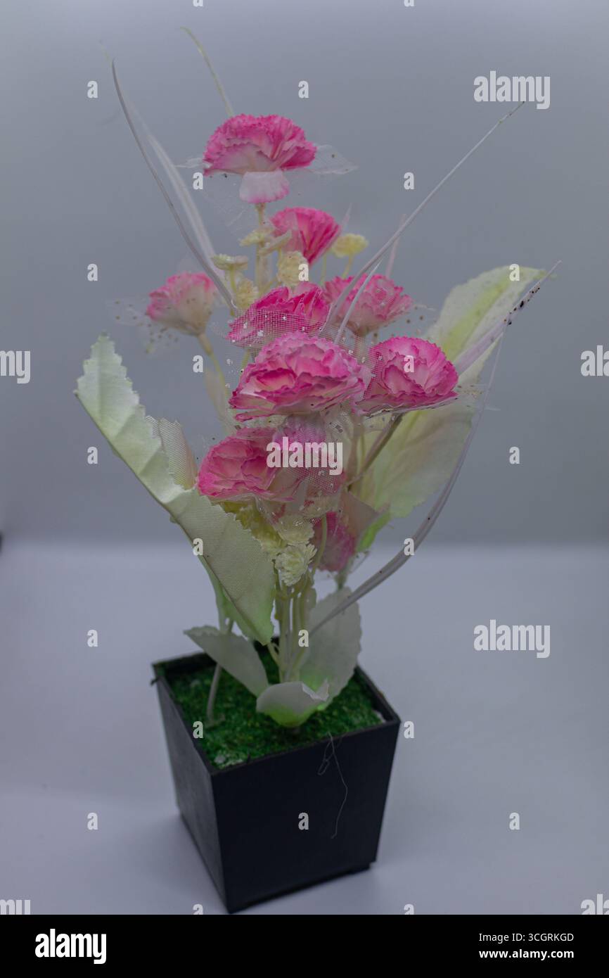 Wohnkultur künstliche Blumenanordnung in weißem Hintergrund Stockfoto