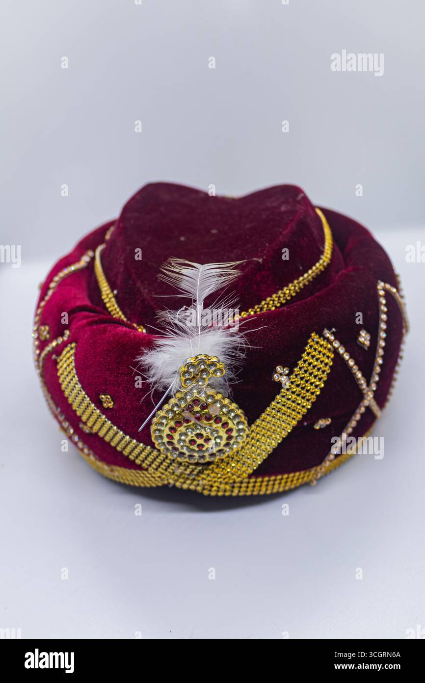Königliches Rot und Goldener Turban mit verziertem Juwel und elegantem Design Stockfoto