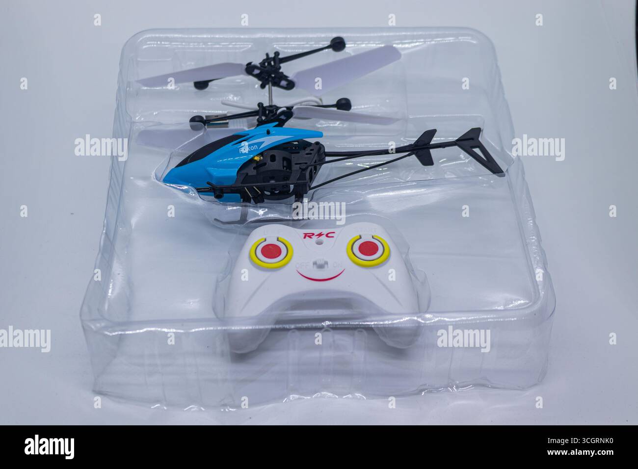 Kleiner blauer RC Hubschrauber und Controller Set auf weißem Tischplattenhintergrund Stockfoto