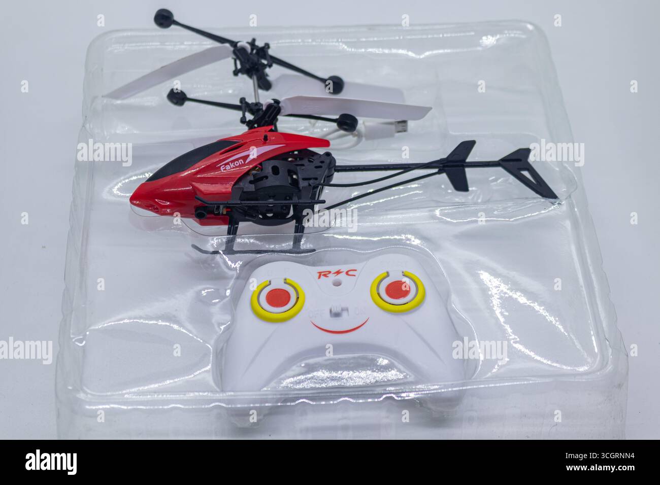 Kleiner Spielzeug Hubschrauber und Controller Set für Indoor Fliegen Spaß in weißem Hintergrund Stockfoto