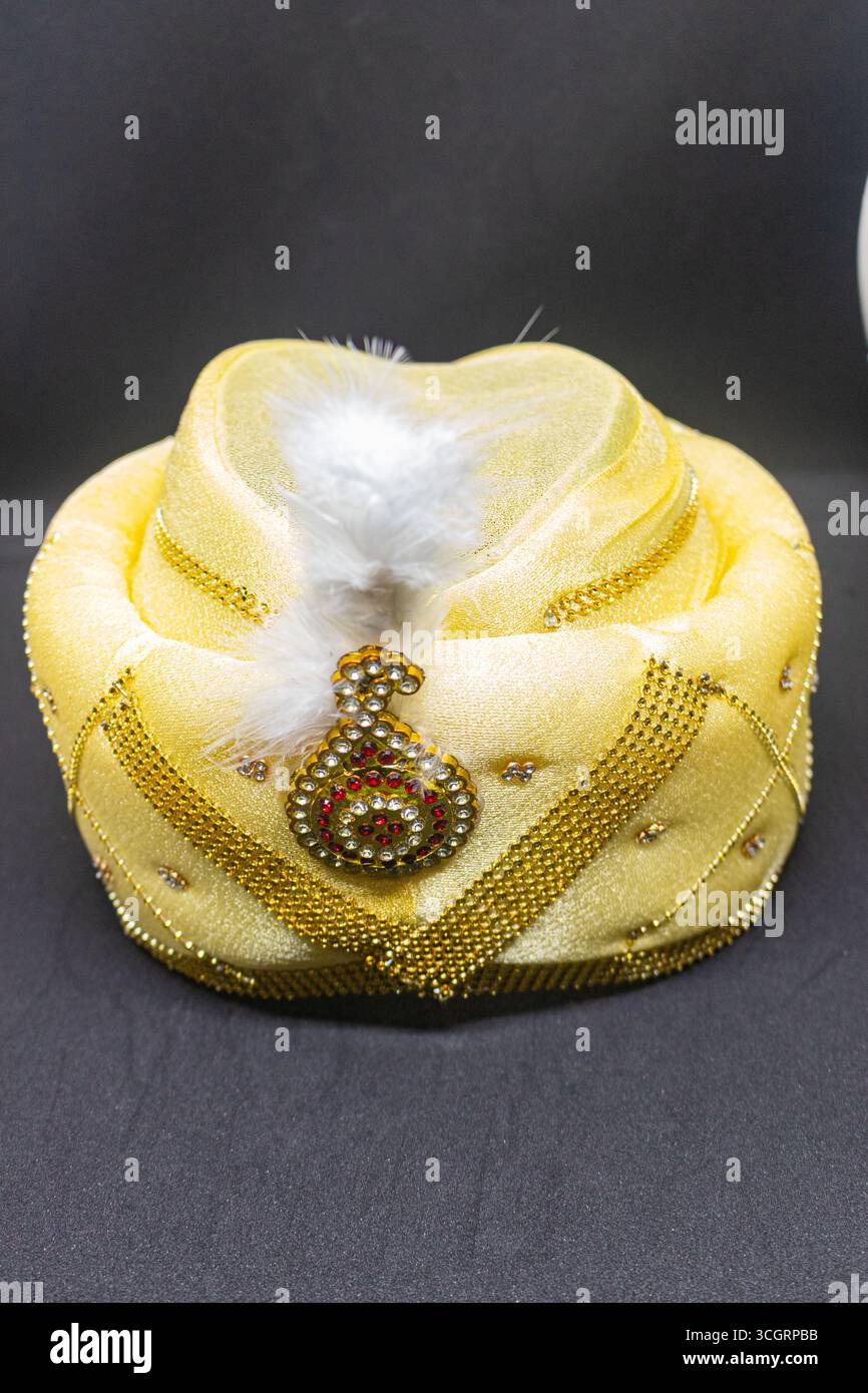 Traditional Grooms Golden Turban mit Juwelenbrosche und Feder Stockfoto