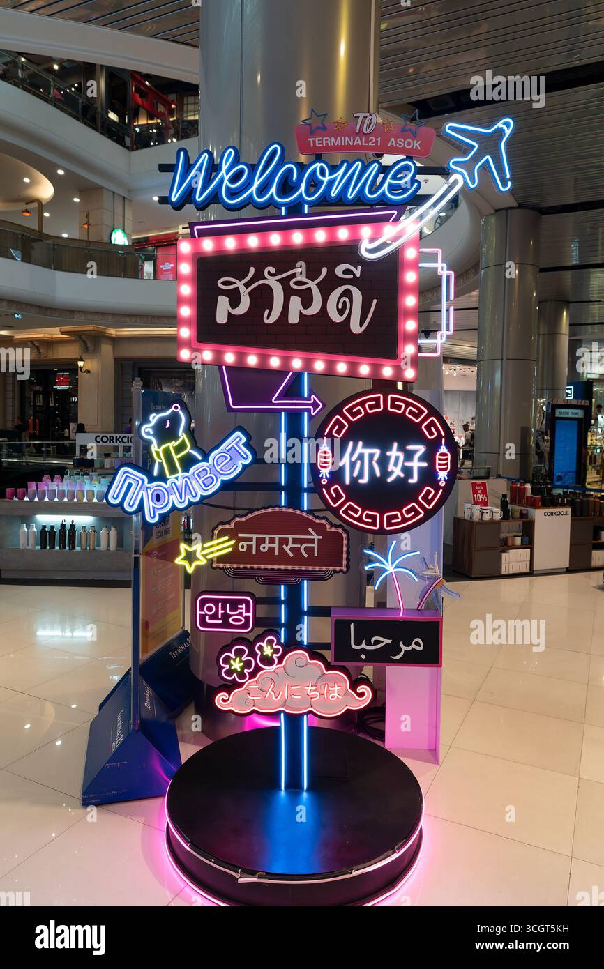 Bangkok, Thailand - 10. Oktober 2024: Eine einladende Themeninstallation am Terminal 21 mit leuchtenden Neonschildern in mehreren Sprachen, einschließlich Welcome Stockfoto