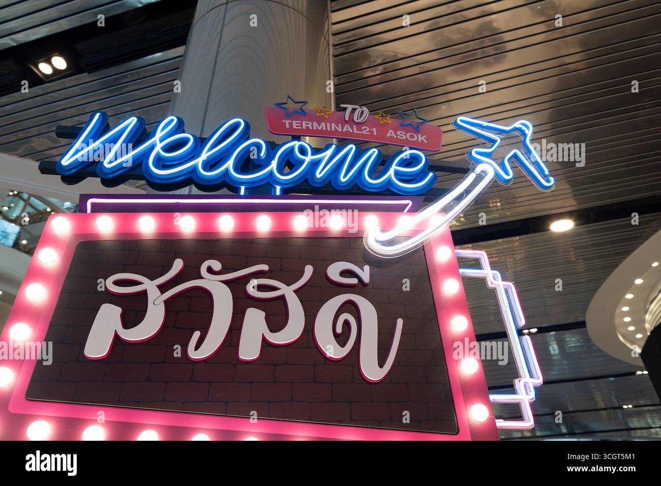 Bangkok, Thailand - 10. Oktober 2024: Nahaufnahme einer einladenden Themeninstallation am Terminal 21 mit leuchtenden Neonschildern in mehreren Sprachen. Stockfoto
