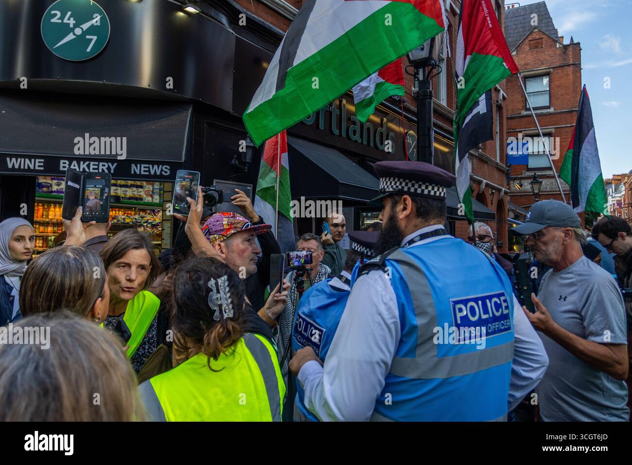 Pro-palästinensische Aktivisten des IJAN veranstalteten vor der israelischen Botschaft in Zentral-London einen „Töpfe und Pfannen“-Protest. Demonstranten schlugen Töpfe und Pfannen, um auf die Krise im Gazastreifen aufmerksam zu machen, stießen aber auf Gegenproteste. Eine bedeutende Polizeipräsenz wurde eingesetzt, um die Gruppen zu trennen und die Ordnung aufrechtzuerhalten. Stockfoto