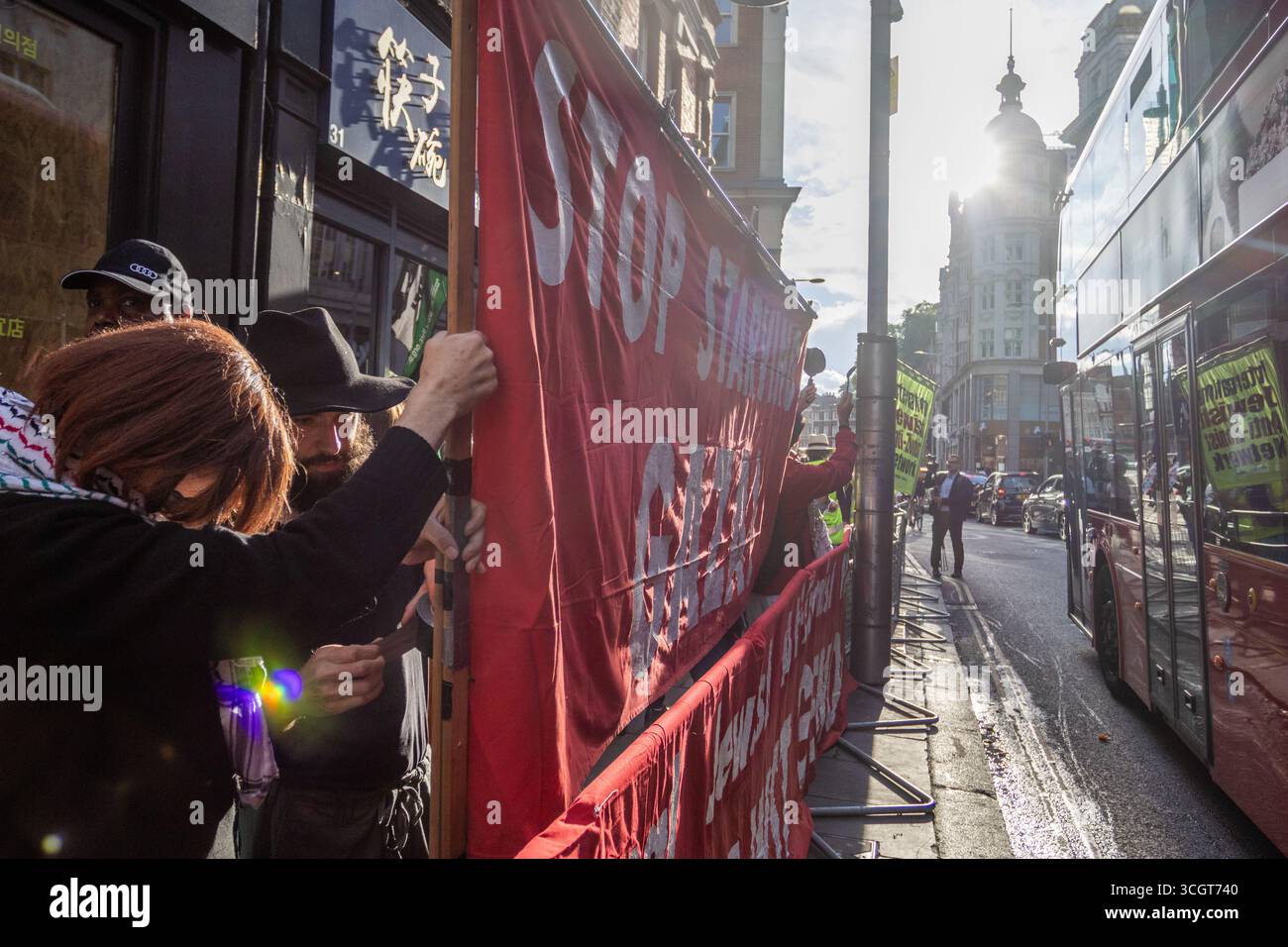 Pro-palästinensische Aktivisten des IJAN veranstalteten vor der israelischen Botschaft in Zentral-London einen „Töpfe und Pfannen“-Protest. Demonstranten schlugen Töpfe und Pfannen, um auf die Krise im Gazastreifen aufmerksam zu machen, stießen aber auf Gegenproteste. Eine bedeutende Polizeipräsenz wurde eingesetzt, um die Gruppen zu trennen und die Ordnung aufrechtzuerhalten. Stockfoto