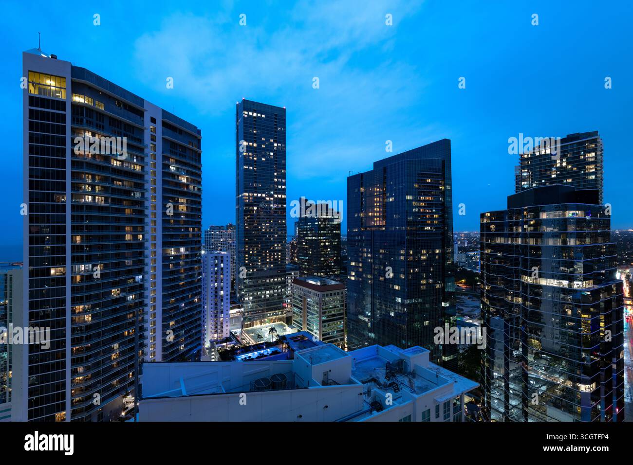 Die pulsierende Skyline von Miamis Viertel Brickell mit beleuchteten Gebäuden unter einem farbenfrohen Abendhimmel. Stockfoto
