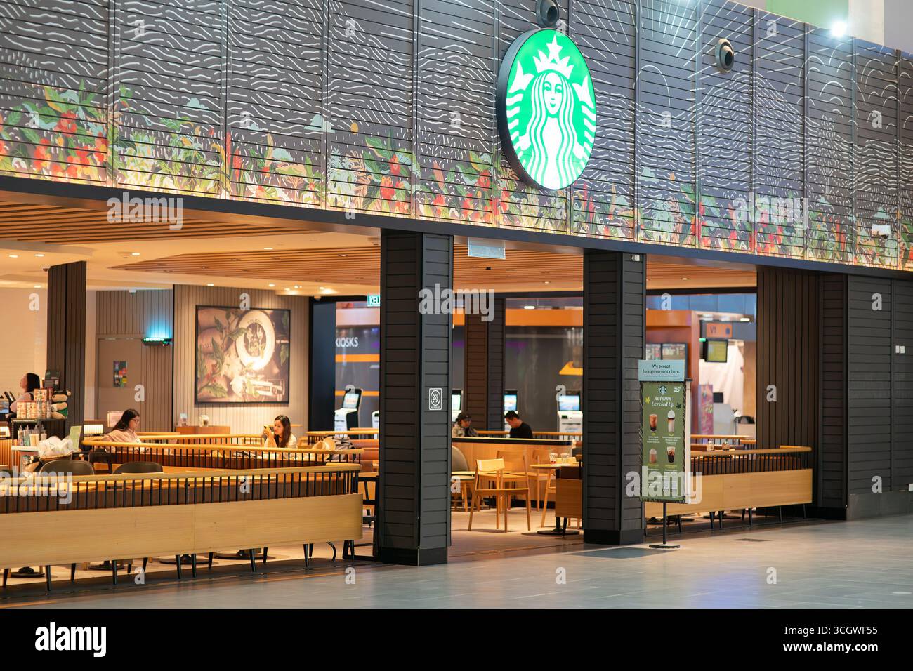 Kuala Lumpur, Malaysia - 21. September 2024: Das Starbucks-Kaffee-Logo mit der Meerjungfrau über dem Eingang des Cafés in KLIA2, markiert den Ort Stockfoto