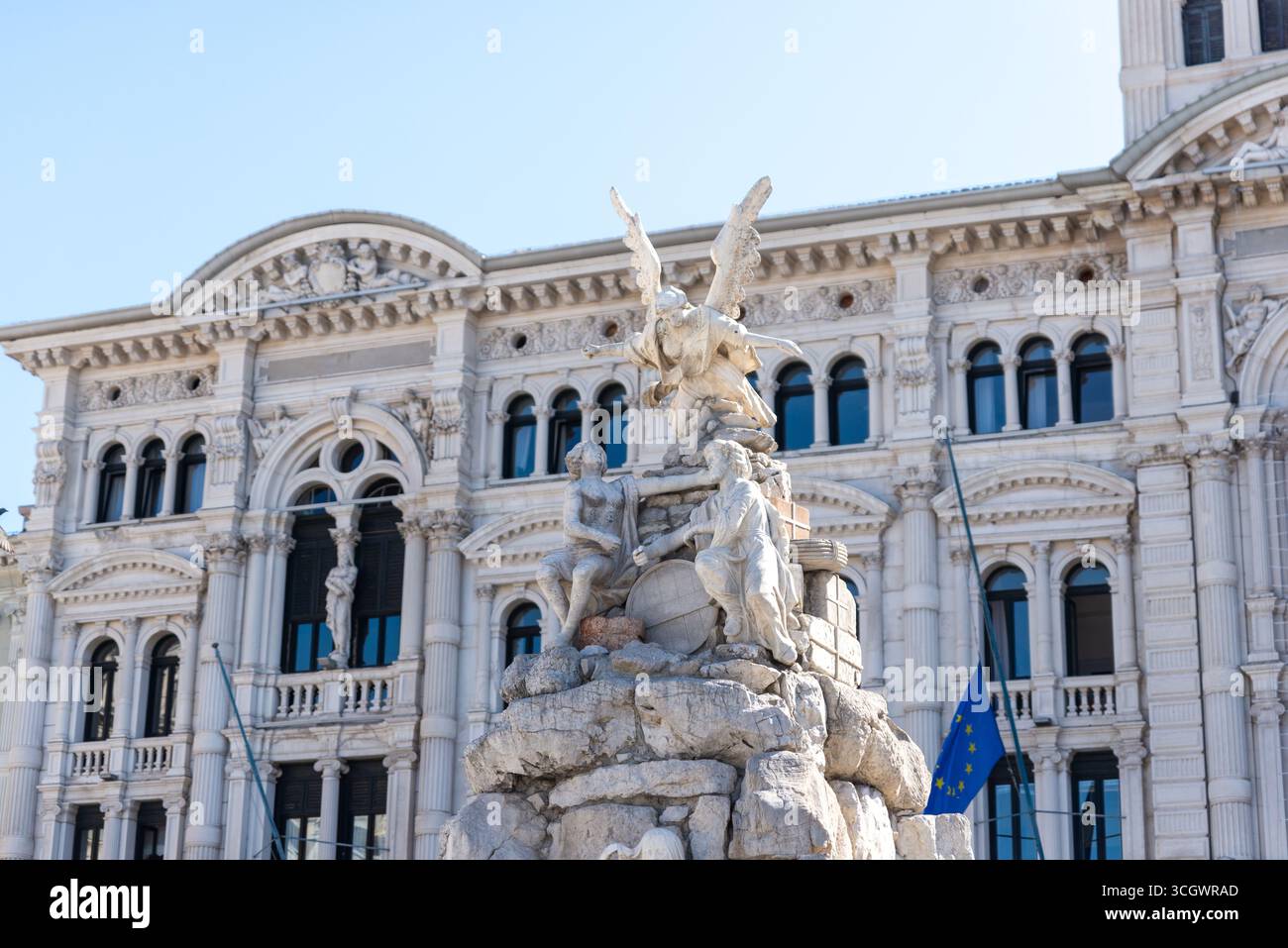 Reich verzierter Brunnen mit Statuen auf der Piazza Unità d’Italia in Triest, eingerahmt von historischer Architektur Stockfoto