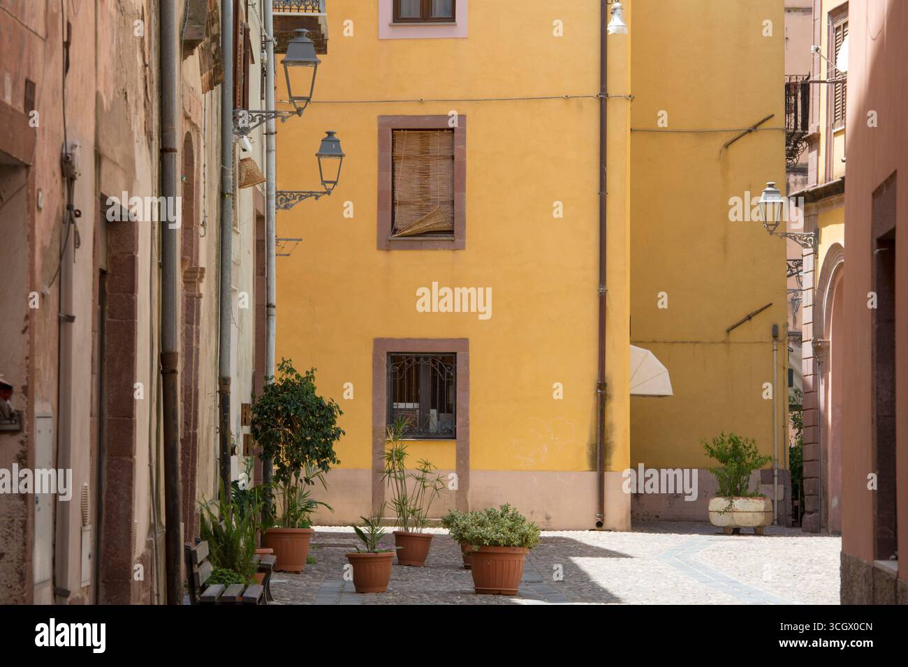 Bosa, Oristano, Sardinien, Italien. Eine farbenfrohe Ecke des historischen Stadtteils Sa Costa mit Topfpflanzen auf Kopfsteinpflaster. Stockfoto