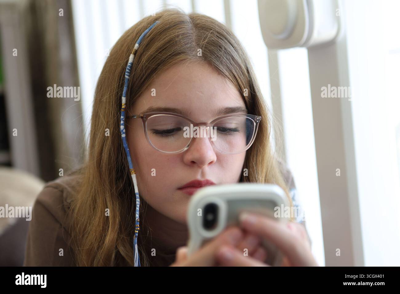 Mädchen schaut auf Telefon Smartphone Bildschirmzeit Bildschirm Zeit Teenager weiblich Stockfoto
