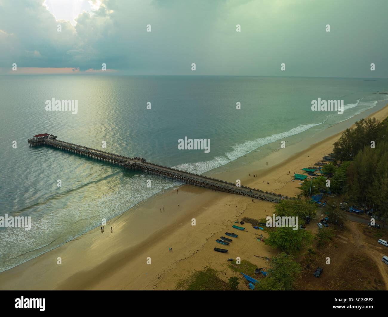 Aus der Vogelperspektive die Brücke erstreckt sich bei schönem Sonnenuntergang bis ins Meer. Atemberaubende Wolken, die sich am blauen Himmel bewegen. Wunderschöne Sonnenuntergangslandschaft, herrliches Licht der Natur Stockfoto