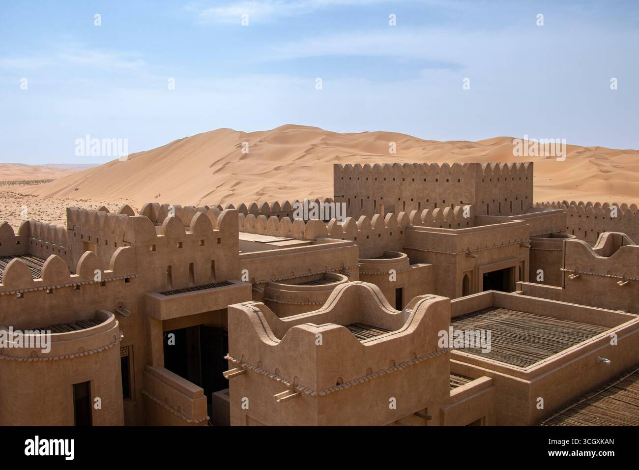 VAE - Liwa - Qasr Al Sarab Dächer - Zinnen-Wände und Windturmdetails erheben sich über weite Dünen Stockfoto
