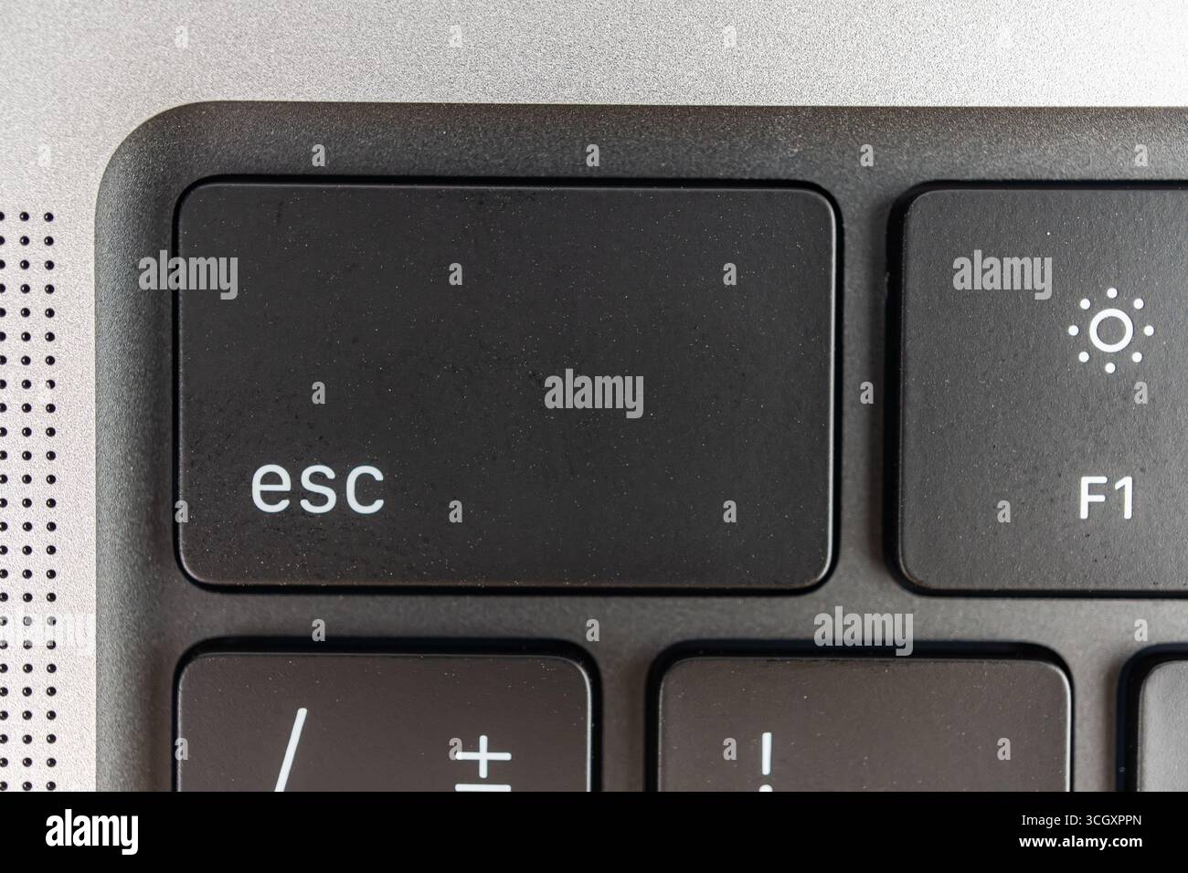 Nahansicht einer Tastaturecke mit hervorgehobener Esc-Taste, teilweise sichtbare Tasten und ein-/Ausschalttaste, die Navigation oder Kurzbefehle im Marketingkontext vorschlägt Stockfoto