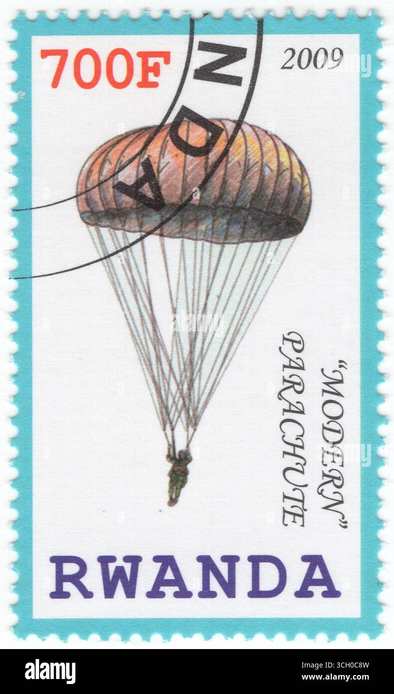 RUANDA - 2009: Mehrfarbige Briefmarke mit 700 Franken, die den modernen Fallschirm darstellt. Ein Fallschirm ist eine Vorrichtung, die den Abstieg eines Objekts durch eine Atmosphäre verlangsamt, indem sie Luftwiderstand oder aerodynamischen Auftrieb erzeugt. Es wird in erster Linie verwendet, um Menschen sicher zu unterstützen, die Flugzeuge in der Höhe verlassen, dient aber auch verschiedenen Zwecken wie der Verlangsamung der Fracht, der Unterstützung bei der Rückgewinnung von Raumkapseln auf der Erde, der Landung von Raumfahrzeugen auf anderen Planeten und der Stabilisierung von Fahrzeugen oder Objekten. Moderne Fallschirme bestehen in der Regel aus strapazierfähigen Stoffen wie Nylon und sind in verschiedenen Formen erhältlich, wie z. B. kuppelförmige, rechteckige und umgedrehte doms Stockfoto