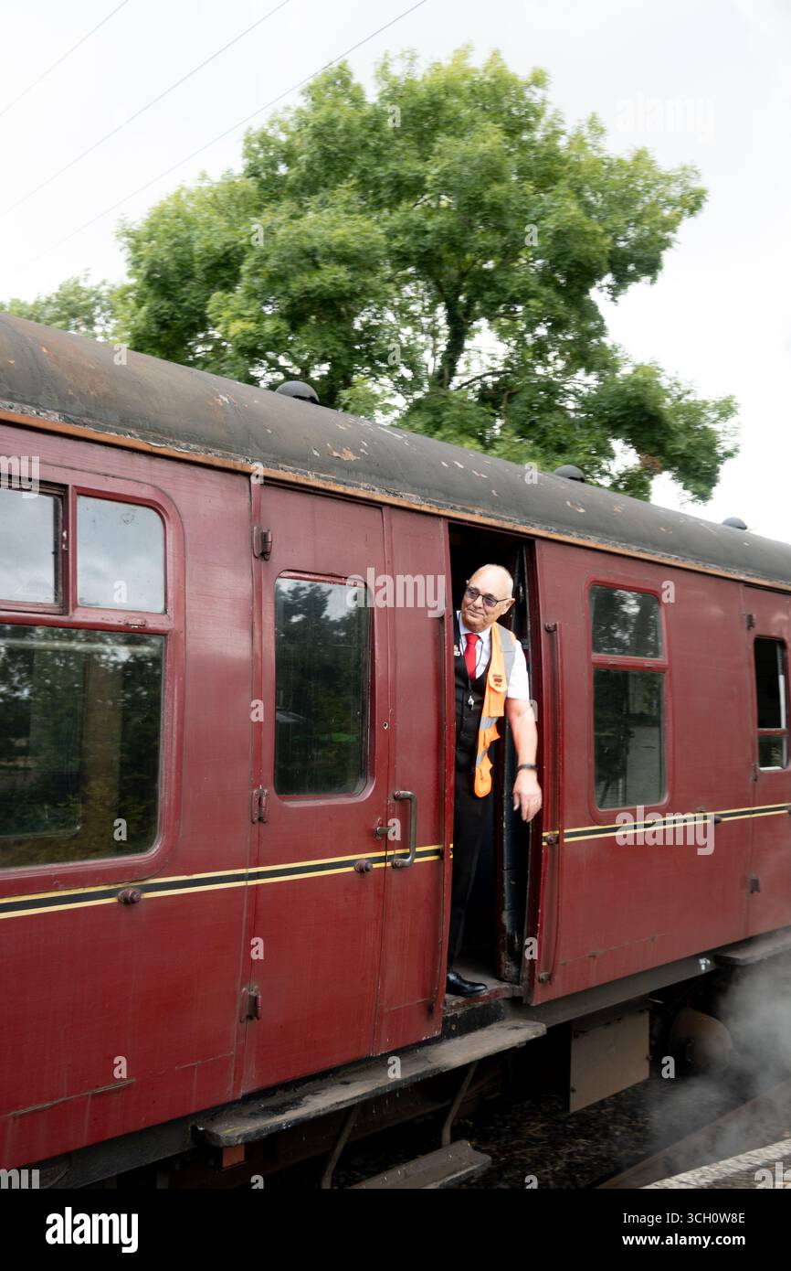 Ein Zugwächter auf der Battlefield Line am Bahnhof Shenton, Leicestershire, England, Großbritannien Stockfoto