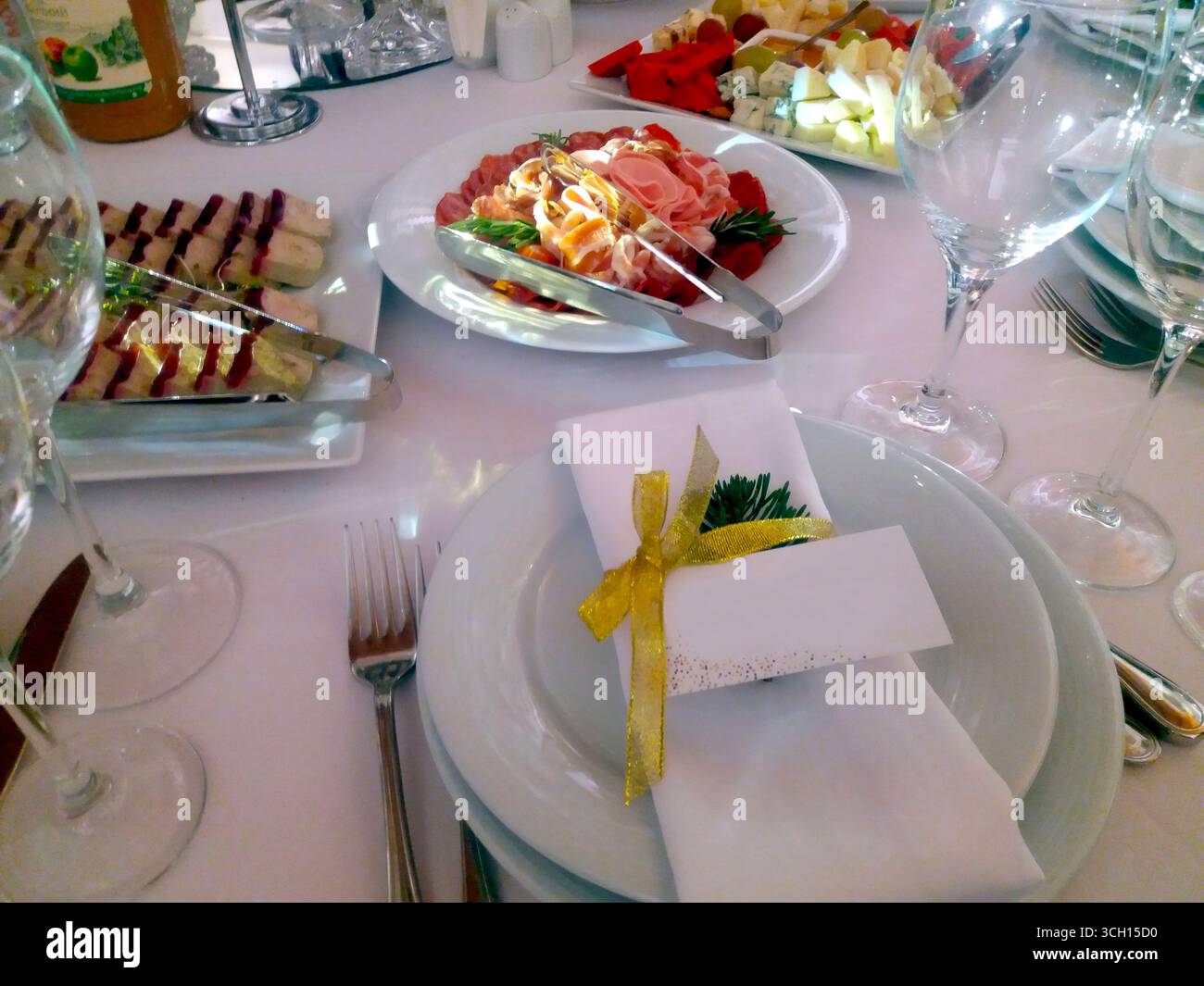 Eleganter Esstisch mit verschiedenen Köstlichkeiten, Gästekarte und dekorativer Serviette für die festliche Atmosphäre. Stockfoto