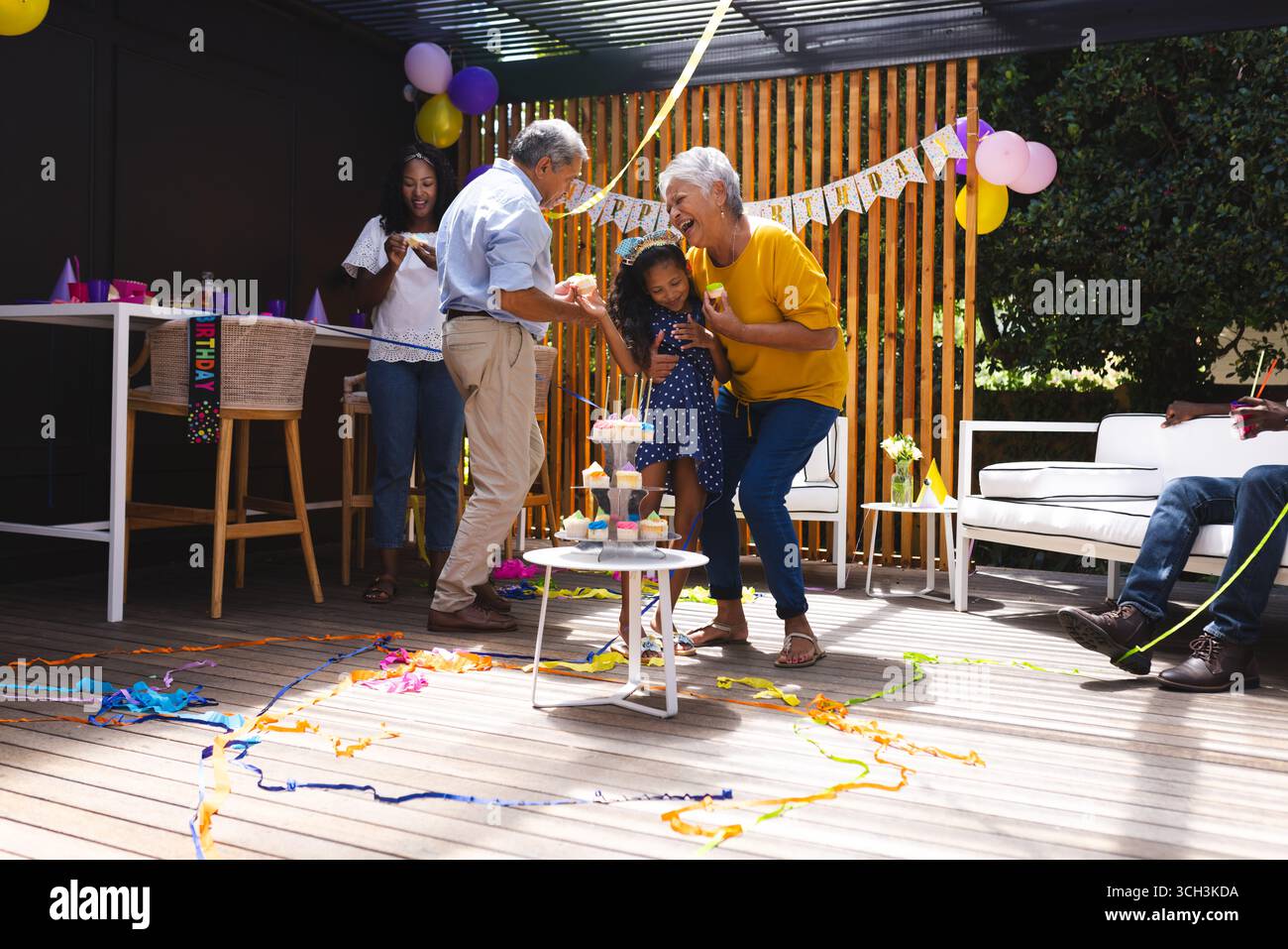 Auf Party, Geburtstag im Garten, fröhliche Familie tanzen mit Kind, Großeltern lächeln Stockfoto