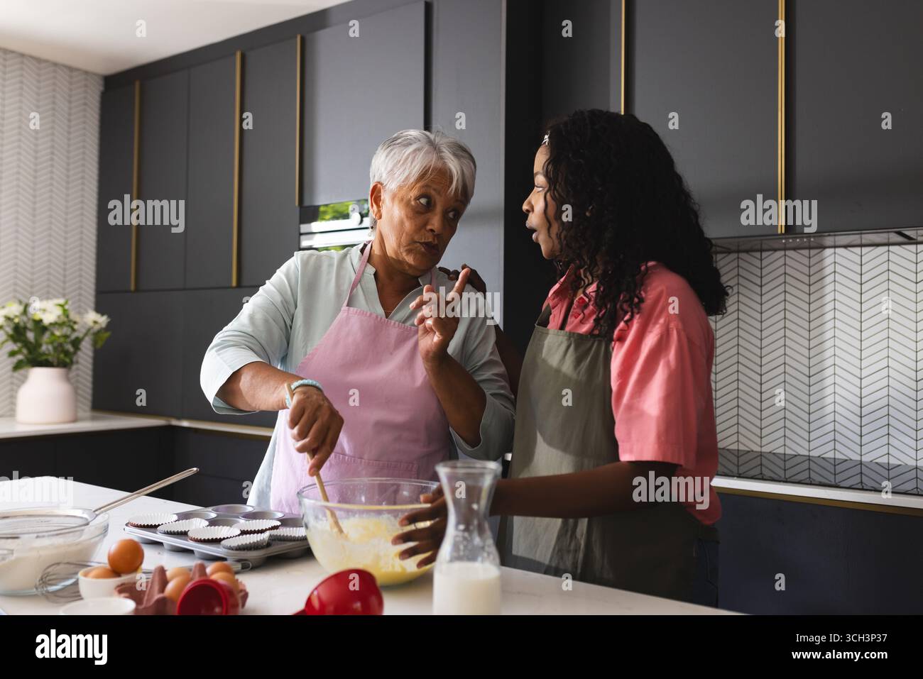 Seniorenmutter und Erwachsene Tochter backen in der modernen Küche, teilen Rezepte, zu Hause Stockfoto