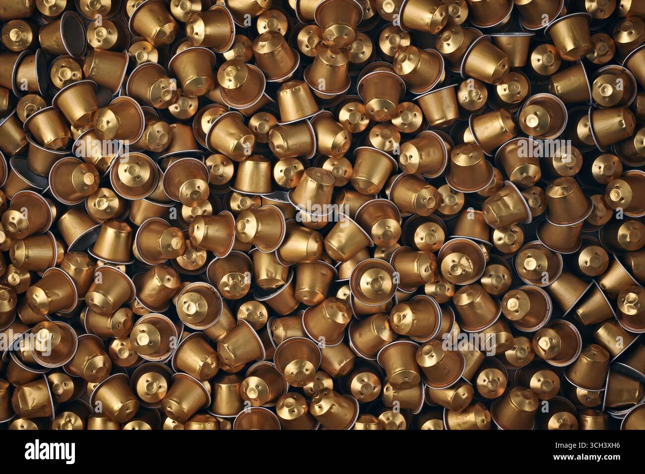 Große Menge goldener Kaffeekapseln. Direkt oben gesehen. Stockfoto